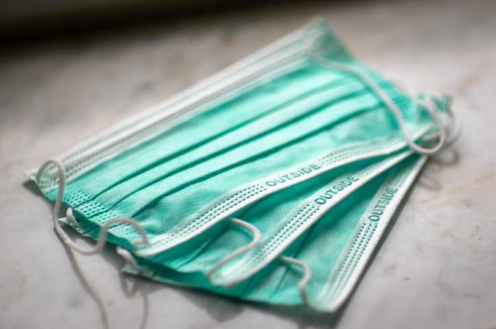three pieces of surgical facemask green and white