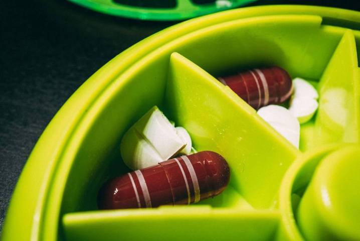 different types of pills placed in a green container close up selective focus