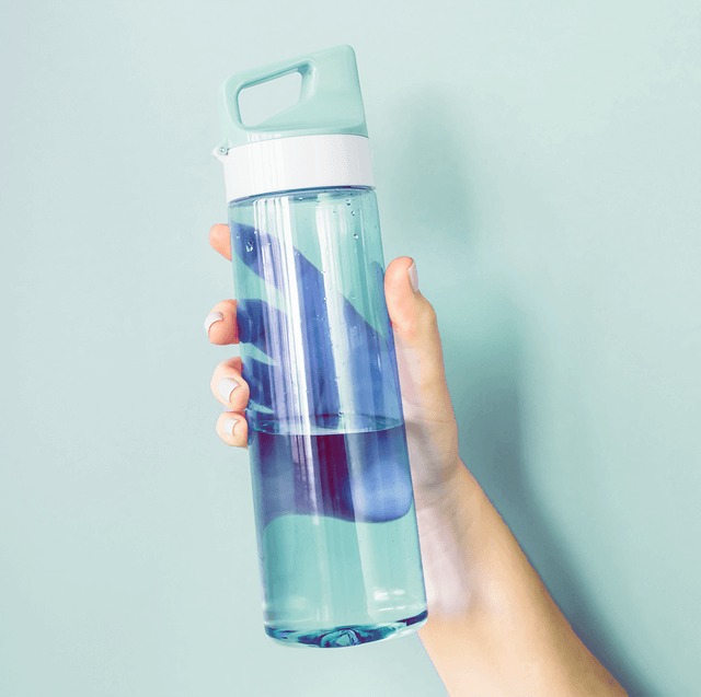 hand holding clear blue plastic bottle quarter filled with water