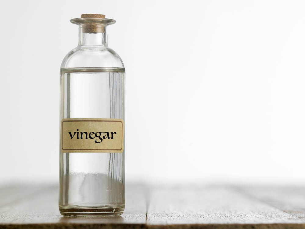 clear liquid inside a clear bottle labeled vinegar