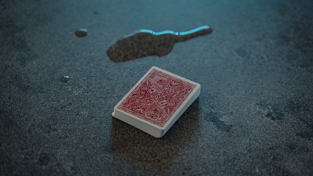 Deck of playing cards on surface with water