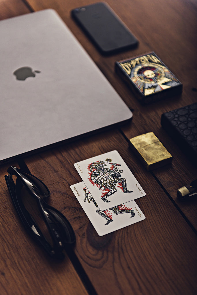 Everyday Carry of Apple MacBook Pro, Apple iPhone 7, RayBan New Wayfarer Sunglasses, Zippo Bronze Lighter, Shrade Oldtimer Pocket Knife, Dystopia Mad Max Inspired Playing Cards by Joker and the Thief, Australian Saltwater Crocodile Leather Card Clip produced by Dan and Dave Industries and Art of Play