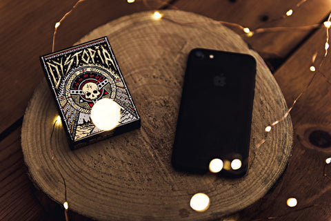 Apple iPhone and Dystopia Playing Cards resting on a wood platform