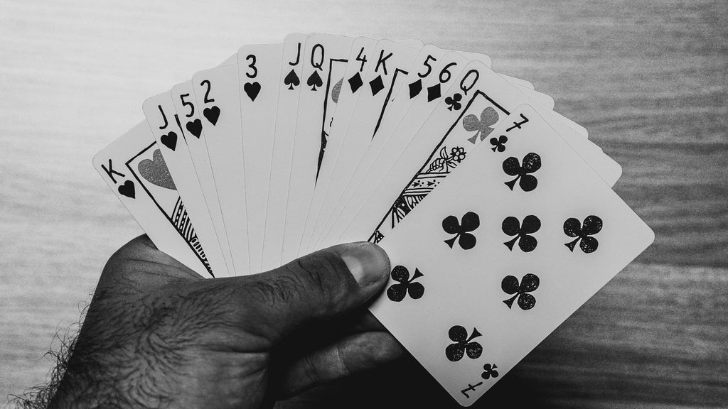 A hand holding a fan of cards ready to play bridge