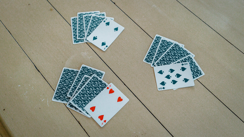 Three piles of playing cards on a table for the drinking game "killer" 