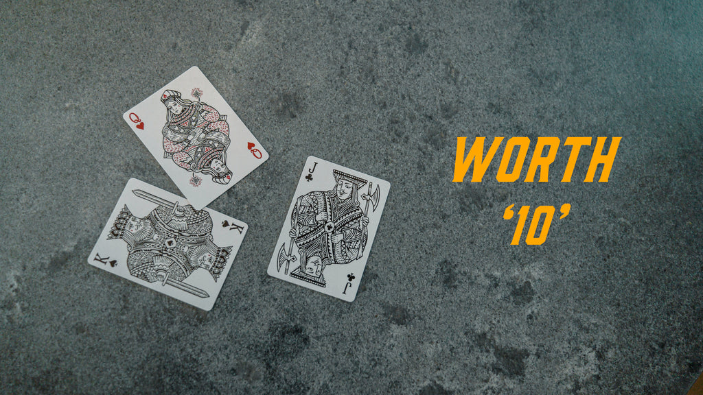 A king, queen, and jack card displayed on a surface with the text "worth 10"