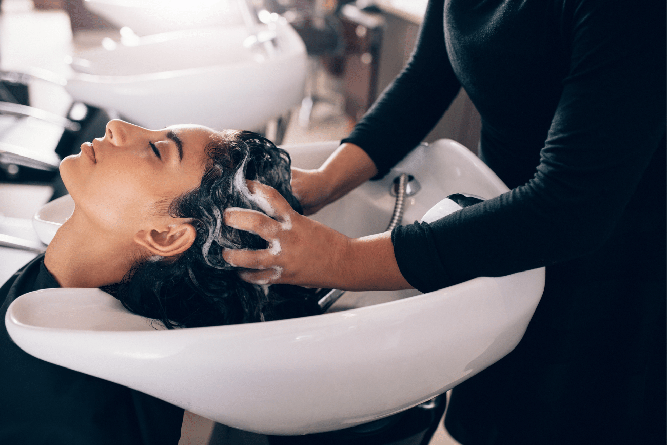 healthy-skin-guide-part-1-hair-stylist-shampooing-customer-hair-in-hair-salon