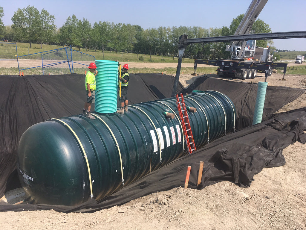 Picture of a fibreglass tank being installed underground for water collection and storage. 