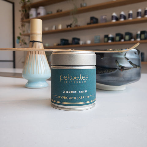 a photograph of a tin of matcha tea and a matcha scoop