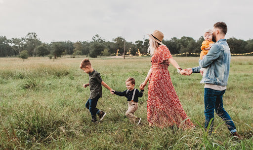 Couple with 3 children walking in a field