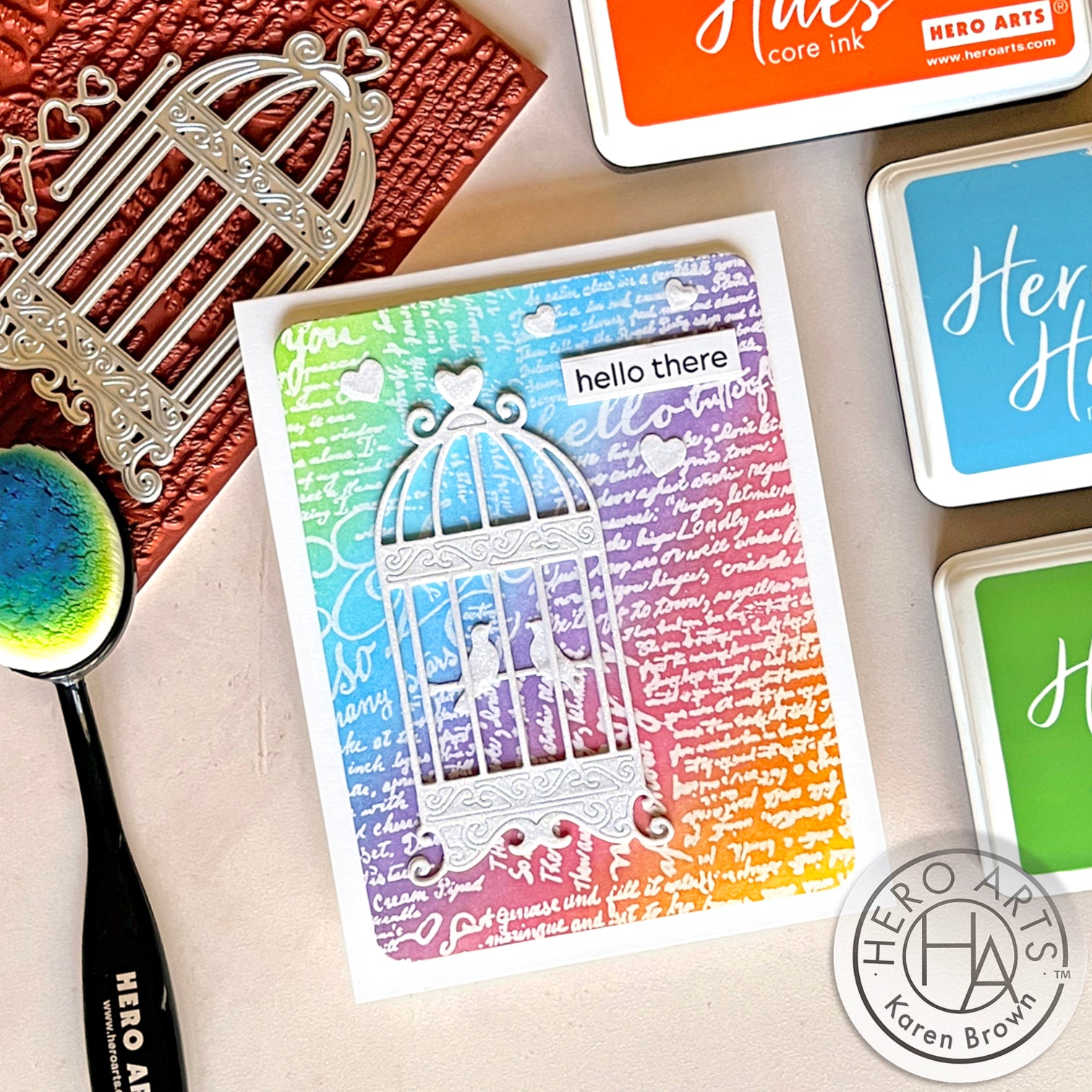 Colorful card with heat embossed background with a die cut white glitter bird cage.