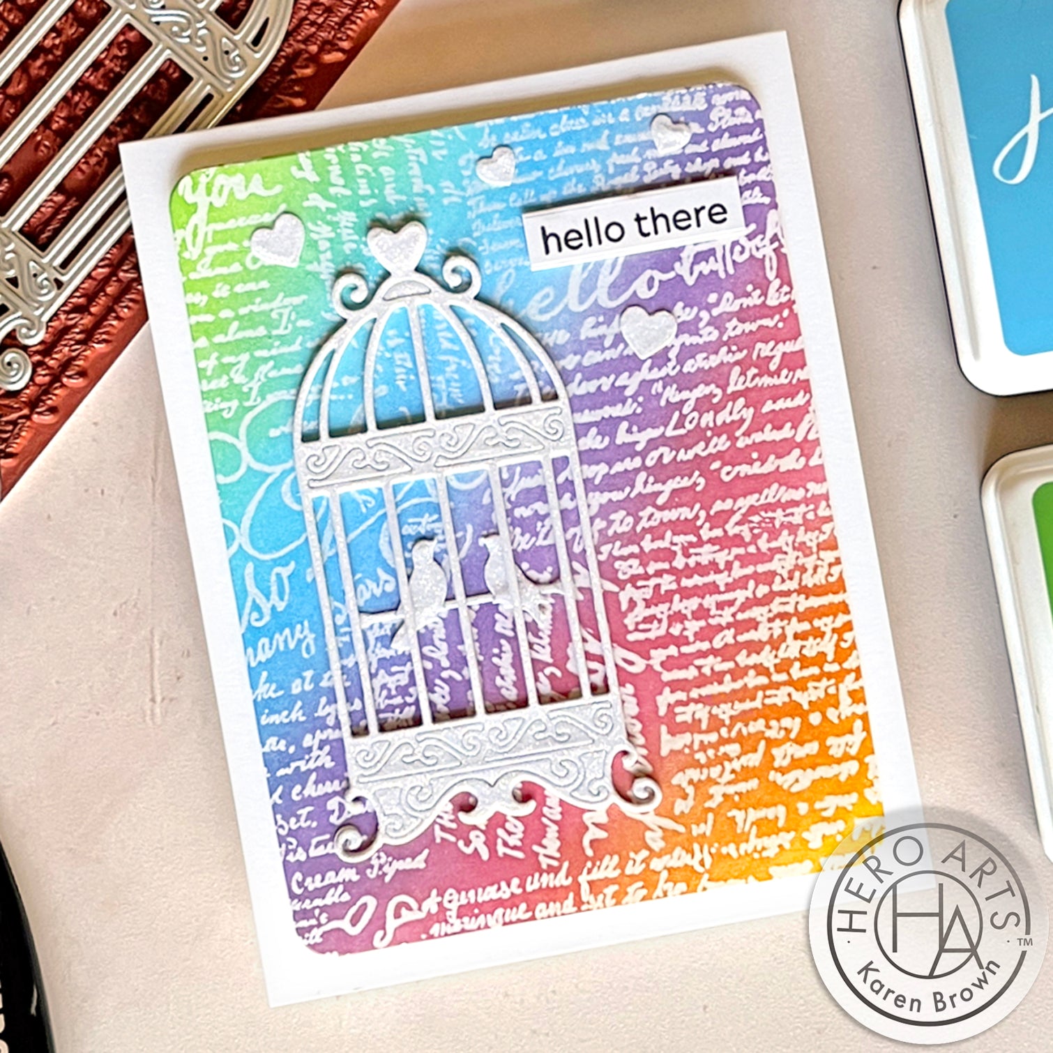 Colorful rainbow ink blend card background with a vintage die cut bird cage.