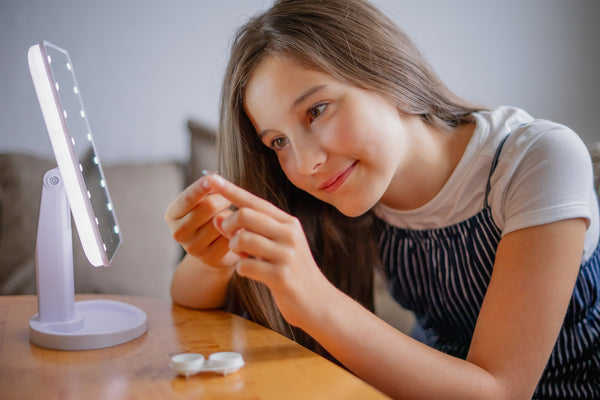 Young girl trying on new contact lenses.