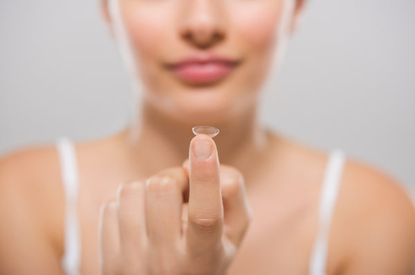 Woman holding biofinity contact lens.