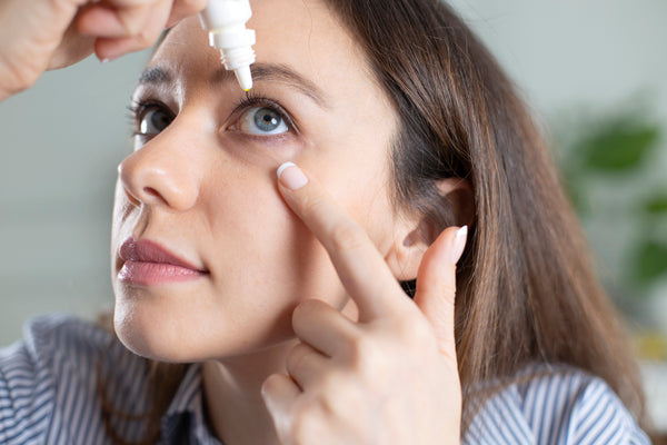 A women putting eye drops.