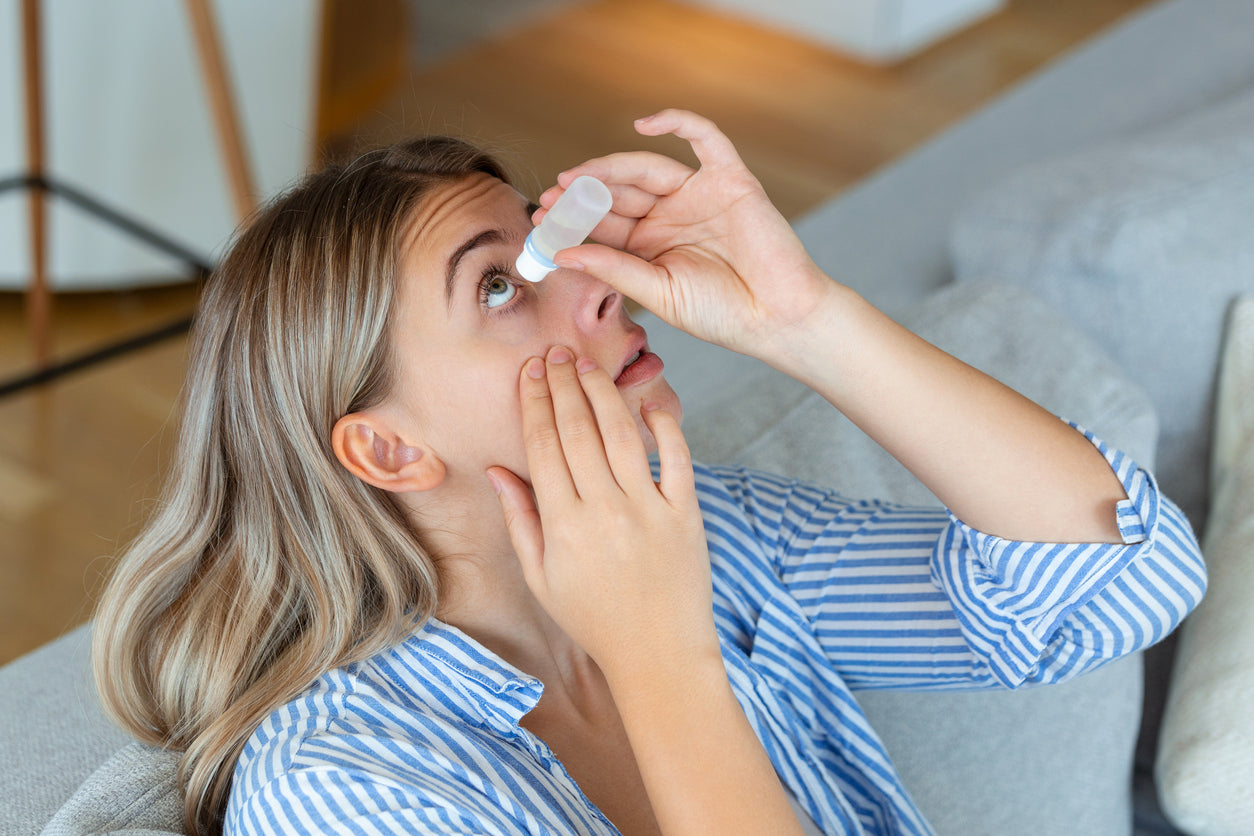 Woman using eye drop.