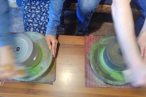 grinding green tea leaves using stone