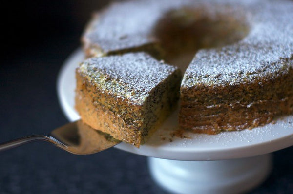 A slice of poppy seed lemon cake being pulled out from the cake.