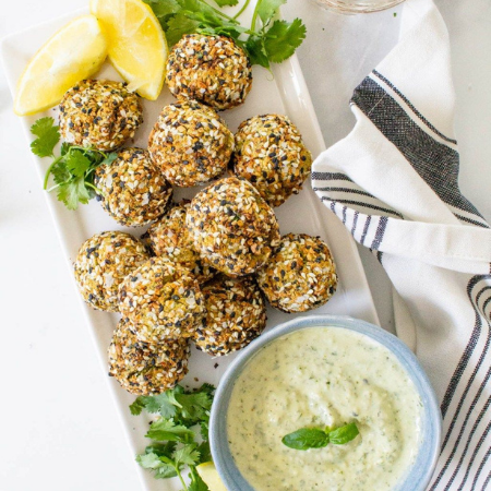 Falafel bites on serving dish with dipping sauce