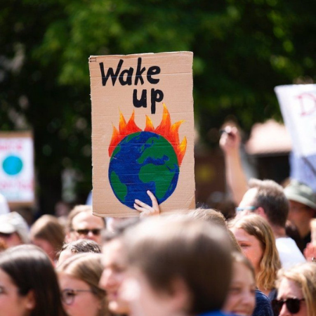 Protest sign from a Climate March saying 'Wake Up' with an image of a burning Earth