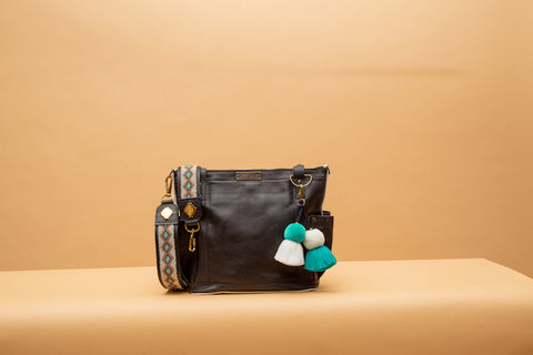 All leather Nena & Co. bag with a Kenya strap and pom demonstrating the add-on system.