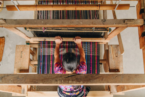 Maribel, a Master Artisan, weaving fabric with a foot loom