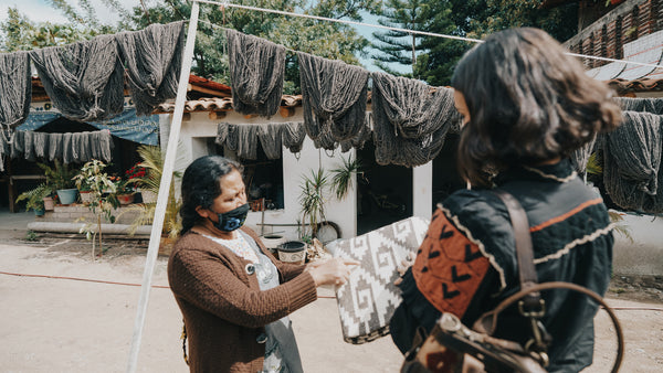 A Guatemalan woman talking with Ali Hynek, the CEO and Founder, of Nena & Co. about some rugs.