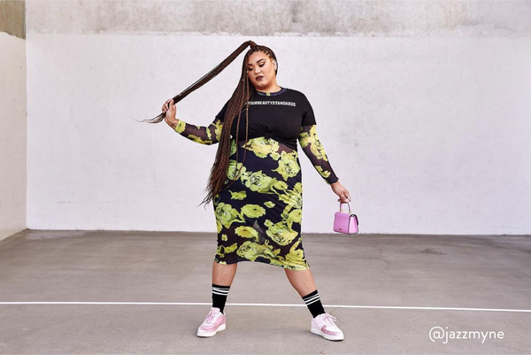 Plus-sized female model posing in a car garage