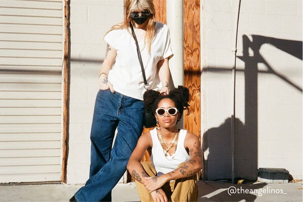 Interracial same sex female couple posing outside on a street for a photo