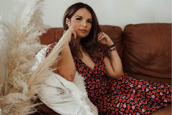 A woman laying on a couch with her hand resting on her cheek.