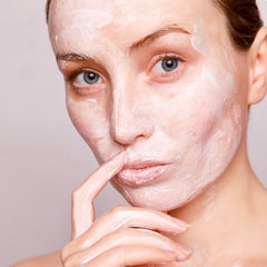 Attractive woman with face cream on her face.