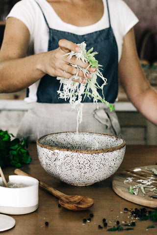 Adding cabbage to the bowl 