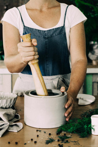 Pounding the cabbage and salt to release the juices to make sauerkraut