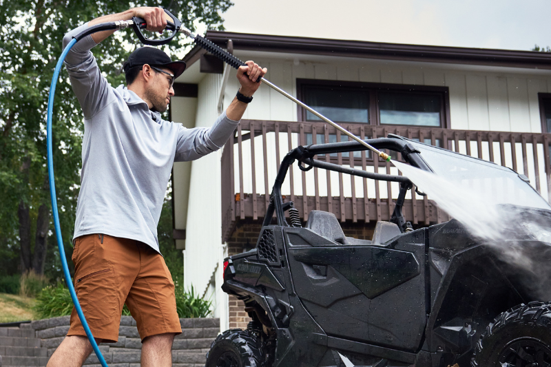 A Man Cleaning a Vehicle Using a Pressure Washer