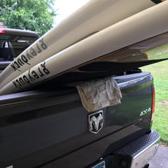 Grey Duck paddle board in the back of a truck.