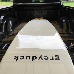 Grey Duck paddle board in the back of a truck.