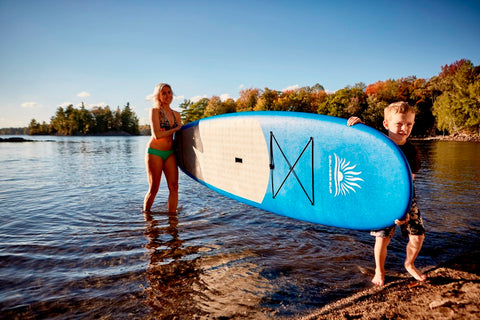 Mother and Son Carrying a Stand Up Paddle Board