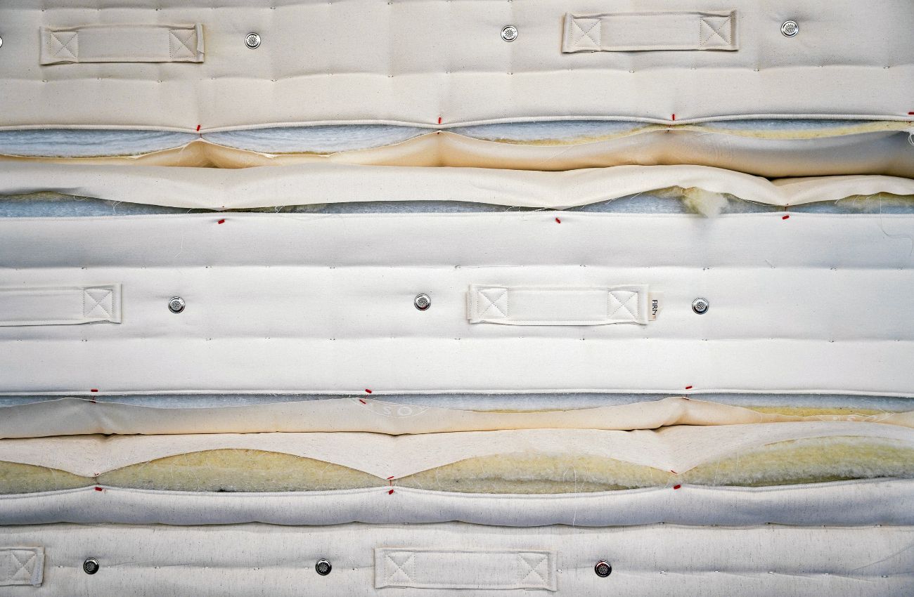 Stack of mattresses showing the inner fillings made from cotton and wool