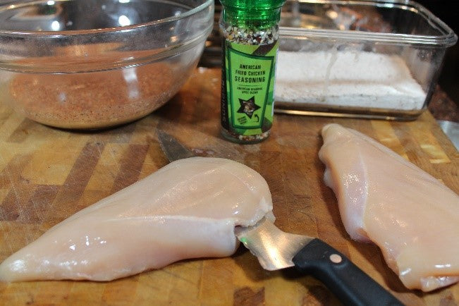 Butterflying a chicken breast for quicker cooking time.