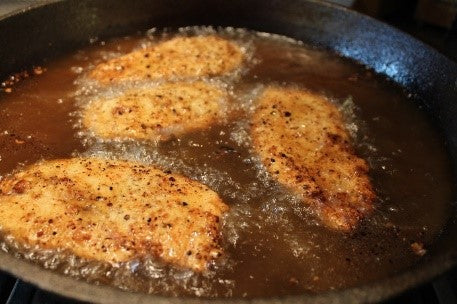 Chicken breast frying after being turned once during frying