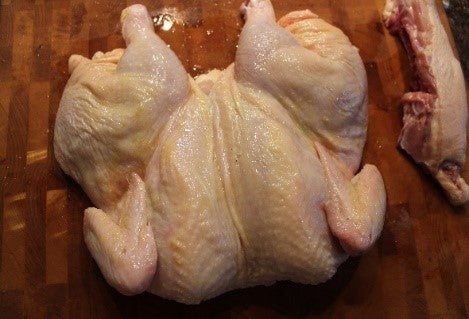 Turn over the chicken and spread it apart.