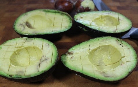 Cut avocados in half and remove the pit.