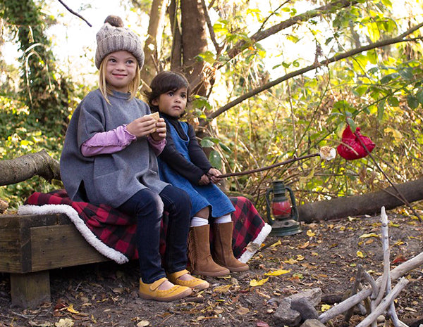 Two little girls by the campfire, one with down syndrome