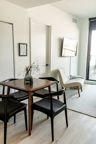 A Square dining table and chair set along with an accent chair exhibited at DK Modern Furniture Gallery in Brooklyn on Bernard, Kelowna.