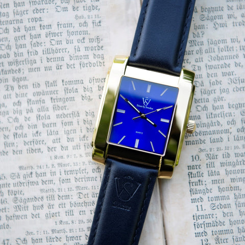 Square watch with blue dial and gold case from SÖNER - on book