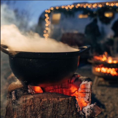 Boiling water in red pot pan on top of stove flames with smokes