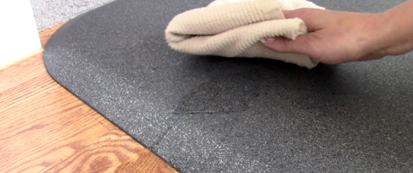 Wiping up spill on WellnessMat with a towel