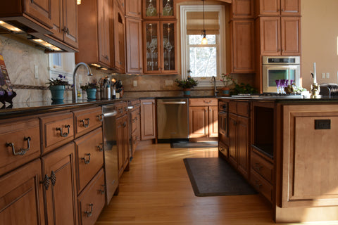 Finished flooring in Christy's studio kitchen, complete with her favorite WellnessMat.