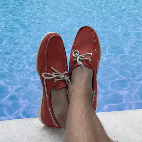 man sitting beside the pool wearing froats red boat shoes