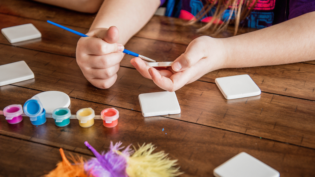 Young kid painting mini canvases